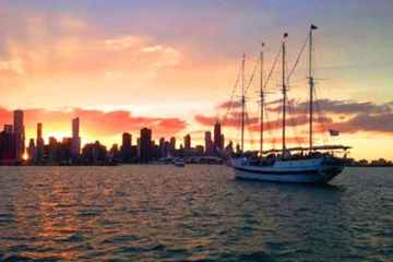 The Tall Ship Windy sailing toward the Chicago skyline at sunset